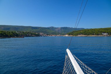 Dağları olan bir sahil kasabasına yaklaşan bir tekneden görüntü