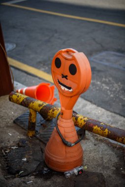 Yüzü boyanmış, caddede duran tuhaf bir trafik konisi..