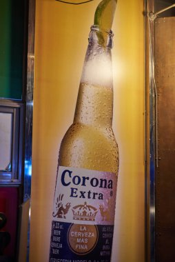 22 Mart 2024 'te Güney Kore, Seul' deki bir barda soğutulmuş Corona Extra birasının reklamını yapan poster.