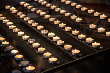 Sırayla dizilmiş birden fazla mum yakın çekim görüntüsü, sıcak ve sakin bir atmosfer yaratır.