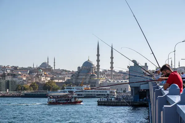 10 Eylül 2022 'de İstanbul' da tarihi eski kenti Karaköy 'e bağlayan Galata Köprüsü' nde balık tutan insanlar görülüyor.