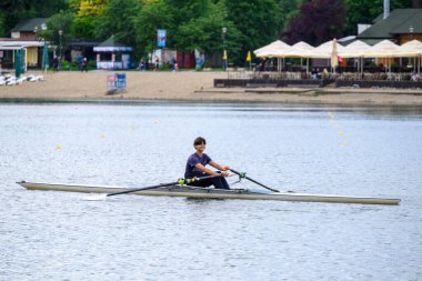 13 Mayıs 2025 'te Sırbistan' ın başkenti Belgrad 'daki Ada Ciganlija gölünde kürek çeken genç adam