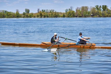 10 Nisan 2021 'de Sırbistan' ın Belgrad kentindeki Tuna nehrinde tahta bir teknede iki kürekçi