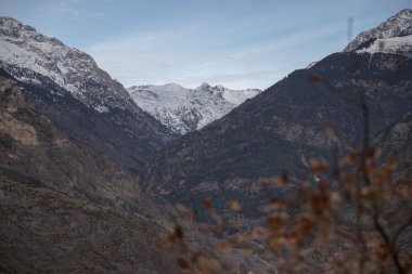 Bulutlu gökyüzü altındaki karlı dağlar Katalonya 'daki Pireneler' deki Boi Vadisi 'nde