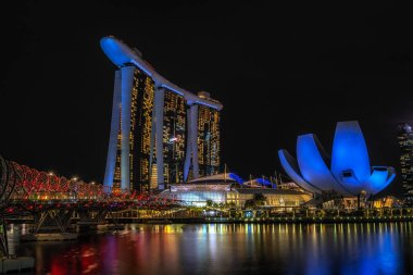 The view of Marina Bay Sands hotel and helix bridge at night. Famous iconic landmarks in Singapore. clipart