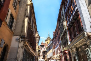 Colmar eski kasaba caddesinde turistler cirit atıyor. Fransa 'nın Colmar şehrinde yarım ahşap renkli Alman evleri alındı..