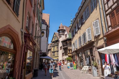 Colmar eski kasaba caddesinde turistler cirit atıyor. Fransa 'nın Colmar şehrinde yarım ahşap renkli Alman evleri alındı. 11 Haziran 2023 'te çekildi.