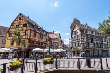 Colmar eski kasaba caddesinde turistler cirit atıyor. Fransa 'nın Colmar şehrinde yarım ahşap renkli Alman evleri alındı. 11 Haziran 2023 'te çekildi.