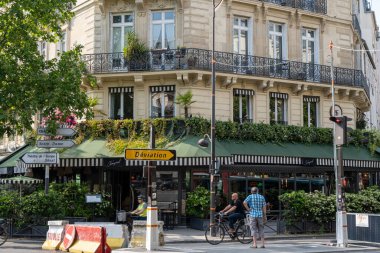 Yakınlarda yerel bir dükkan olan Paris sokak lambası manzarası. 13 Haziran 2023 'te Paris, Fransa sokaklarında çekildi.