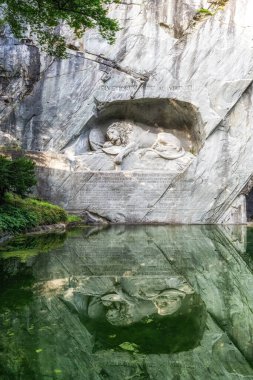 Küçük bir gölet suyuna yansıyan Lucerne 'in ünlü aslan heykeli. Lucerne, İsviçre 'de çekilmiş.