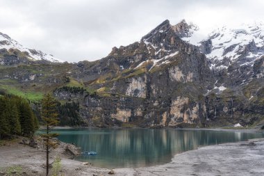 The view of Oeschinenee Lake and Oeschinen valley amongst Bernese Alps mountain tops. Famous tourist attraction in Switzerland clipart