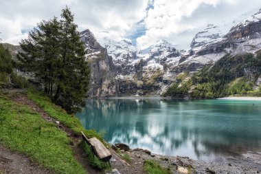 Bernese Alpleri 'nin tepelerindeki Oeschinenee Gölü ve Oeschinen Vadisi manzarası. İsviçre 'nin ünlü turistik merkezi.