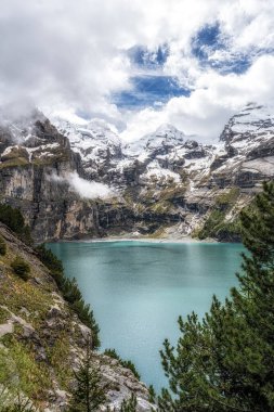 Bernese Alpleri 'nin tepelerindeki Oeschinenee Gölü ve Oeschinen Vadisi manzarası. İsviçre 'nin ünlü turistik merkezi.