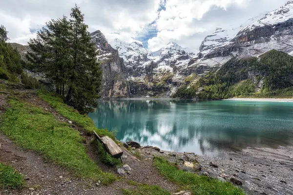 Bernese Alpleri 'nin tepelerindeki Oeschinenee Gölü ve Oeschinen Vadisi manzarası. İsviçre 'nin ünlü turistik merkezi.