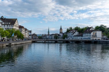 Zürih, St. Peter ve sahtekar kilise saat kuleleri manzaralı nehir manzaralı eski kasaba manzarası. 26 Mayıs 2024 'te çekilmiş. Zürih, İsviçre