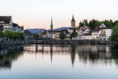 zurich old town sunrise with the view of kirche fraumunster and saint peter church over the limmat river. Taken in Zurich, Switzerland on May 26th 2024 clipart