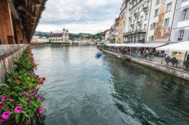 İsviçre, Lucerne 'deki Chapel Köprüsü veya Kapellbrucke. Dekoratif çiçekler ve Lucerne şehrinin manzarasıyla çekilmiş. Lucerne, İsviçre 27 Mayıs 2024 tarihinde alındı