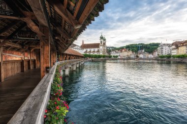 İsviçre, Lucerne 'deki Chapel Köprüsü veya Kapellbrucke. Dekoratif çiçekler ve Lucerne şehrinin manzarasıyla çekilmiş. Lucerne, İsviçre 27 Mayıs 2024 tarihinde alındı