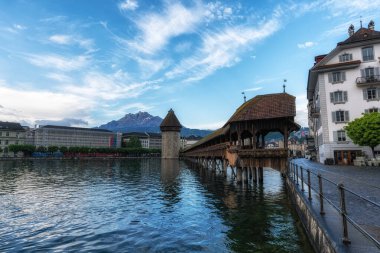 Gündoğumunda Reuss nehrinin üzerindeki şapel köprüsünün manzarası. İsviçre, Lucerne 'de ünlü bir simgedir. 27 Mayıs 2024 'te çekildi.