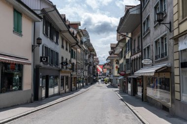 Yol boyunca çeşitli dükkanları ve işletmeleri olan küçük Thun kasabası. 27 Mayıs 2024 'te İsviçre' nin Thun kentinde çekildi.