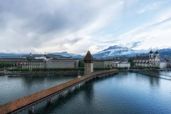 Stock image the view of chapel bridge and mount pilatus over the Reuss river. Famous landmark in Lucerne, Switzerland. Taken on May 27 2024