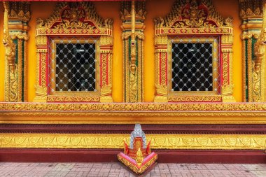 Gold colored temple walls in Wat Si Muang captured in Vientiane, Laos clipart