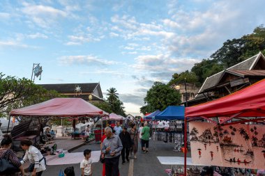 Luang Prabang Gece Pazarı gün batımında ele geçirildi. Luang Prabang, Laos 'taki Sisavangvong Yolu' ndaki ünlü Gece Pazarı. 28 Ekim 2024 'te çekildi.