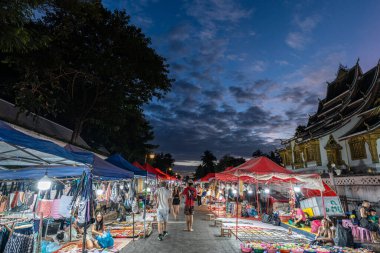 Luang Prabang Gece Pazarı gece saatlerinde ele geçirildi. Luang Prabang, Laos 'taki Sisavangvong Yolu' ndaki ünlü Gece Pazarı. 28 Ekim 2024 'te çekildi.
