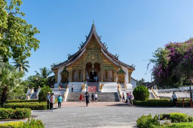 Haw Phra Bang Tapınağı manzarası ve turistler geliyor. Luang Prabang 'daki ünlü tapınak, Laos. 29 Ekim 2024 'te çekildi