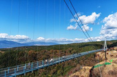 View of Mt Fuji and Mishima Skywalk suspension bridge. Taken during autumn fall foliage season. Famous tourist attraction in Mishima, Shizuoka, Japan. December 2nd 2024 clipart