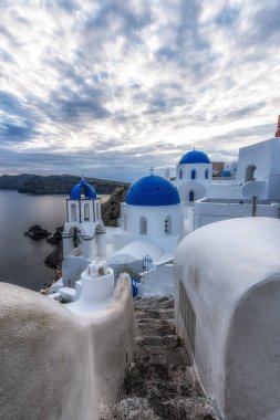 Famous Oia Blue Domed church view in Santorini, Greece taken during sunset hours. clipart