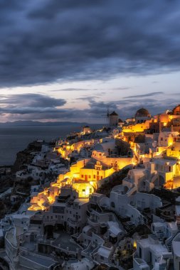 Oia Santorini 'nin günbatımı manzaralı ünlü beyaz renkli sahil köyü. Yunanistan 'ın Santorini kentinde ünlü günbatımı sahnesi çekildi