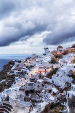 Oia Santorini 'nin gündoğumu manzaralı ünlü beyaz renkli sahil köyü. Yunanistan 'ın Santorini kentinde ünlü gündoğumu noktası alındı