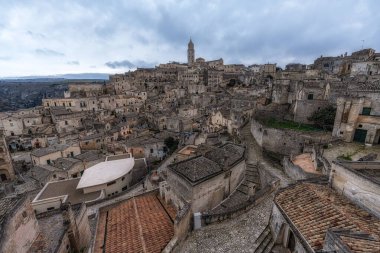 Sassi di Matera 'nın günbatımı manzarası. Birbirine bağlı geniş mağara evleri dar sokaklar boyunca. Matera, İtalya 'da ünlü ikonik cazibe