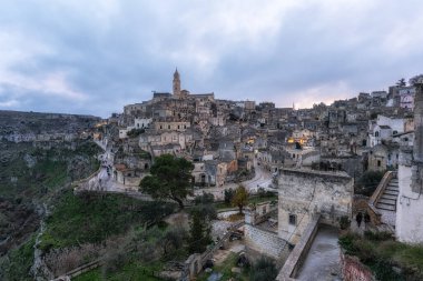 Sassi di Matera 'nın günbatımı manzarası. Birbirine bağlı geniş mağara evleri dar sokaklar boyunca. Matera, İtalya 'da ünlü ikonik cazibe