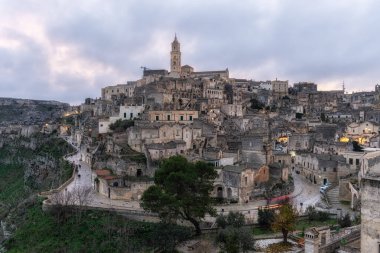 Sassi di Matera 'nın günbatımı manzarası. Birbirine bağlı geniş mağara evleri dar sokaklar boyunca. Matera, İtalya 'da ünlü ikonik cazibe