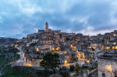 Sassi di Matera 'nın günbatımı manzarası. Birbirine bağlı geniş mağara evleri dar sokaklar boyunca. Matera, İtalya 'da ünlü ikonik cazibe