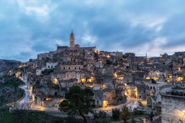 Sunset View of Sassi di Matera. Interconnected vast areas of cave dwellings homes along narrow streets. Famous iconic attraction in Matera, Italy clipart