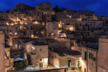 Sassi di Matera 'nın gece manzarası. Birbirine bağlı geniş mağara evleri dar sokaklar boyunca. Matera, İtalya 'da ünlü ikonik cazibe