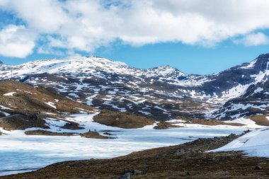 Sognefjellet Yolu karlı dağlarla ve donmuş gölle çevrili. Norveç 'te çekildi
