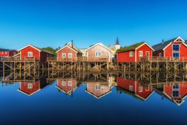 Reine 'de kırmızı rorbu kulübeleri, Norveç yaz boyunca suyun yansımalar için sakin olduğu zamanlarda çekildi.