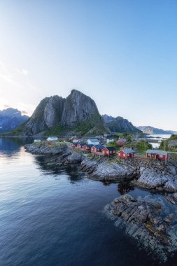 Norveç, Lofoten Adaları 'nda ikonik kırmızı rorbu balıkçı kulübeleri olan Hamnoy balıkçı köyü