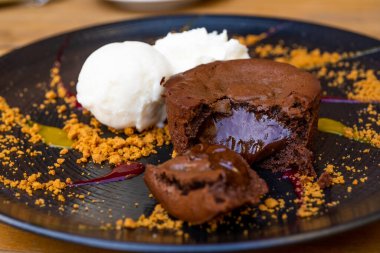 Dondurma toplarıyla servis edilen bir tabak lezzetli, sıcak çikolatalı kek. Süslü tabakta lav keki. Yüksek kalite fotoğraf