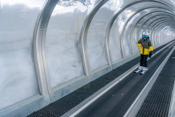 Kayak Yapan Bir Çocuk Cam Tüneldeki Sihirli Halı Kayak Asansöründe — Stok fotoğraf