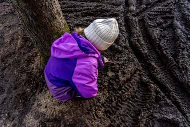 Çamurlu arka planda ormanda oynayan kız. Yüksek kalite fotoğraf