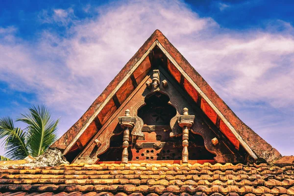Punnamada Resort, Alappuzha, Kerala, India - 19.01.2023: Carving wood gable roof on a resort hotel in India, Alappuzha, Kerala. Wooden roof structure, traditional indian style. Hight quality photo. 