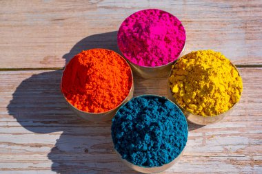 Colorful powder organic Gulal colors in bowls for Indian Holi festival. Wooden background. High quality photo