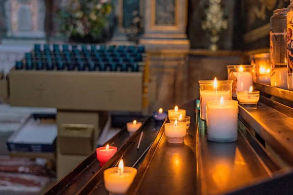 Candles in the Catholic Church. Beautiful glass windows with the evening light on the background. High quality photo