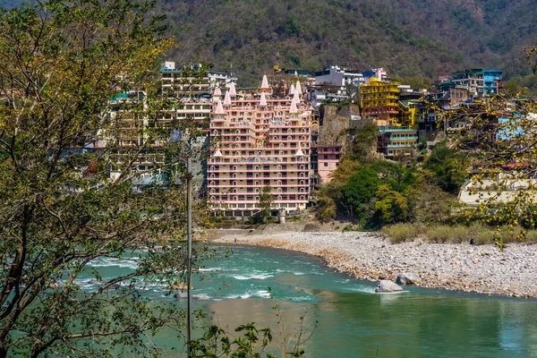 Rishikesh, Uttarakhand, Hindistan - 28.03.2023: Rishikesh 'teki Güzel Ganga Nehri Ashram ve tapınak binalarıyla çevrili. Tamamen temiz nehir suyu. Yüksek kalite fotoğraf