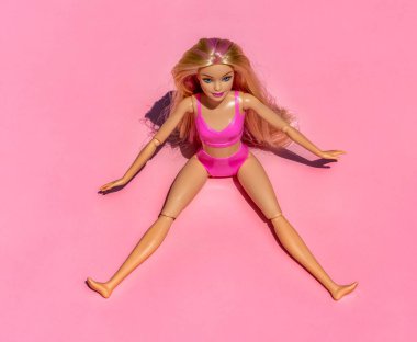 Güzel, Fransa - 29 Temmuz 2023 pembe arka planda pembe mayo ve aksesuar giyen sarışın bebek. Düz tabanlı modern Barbie. Yüksek kalite fotoğraf